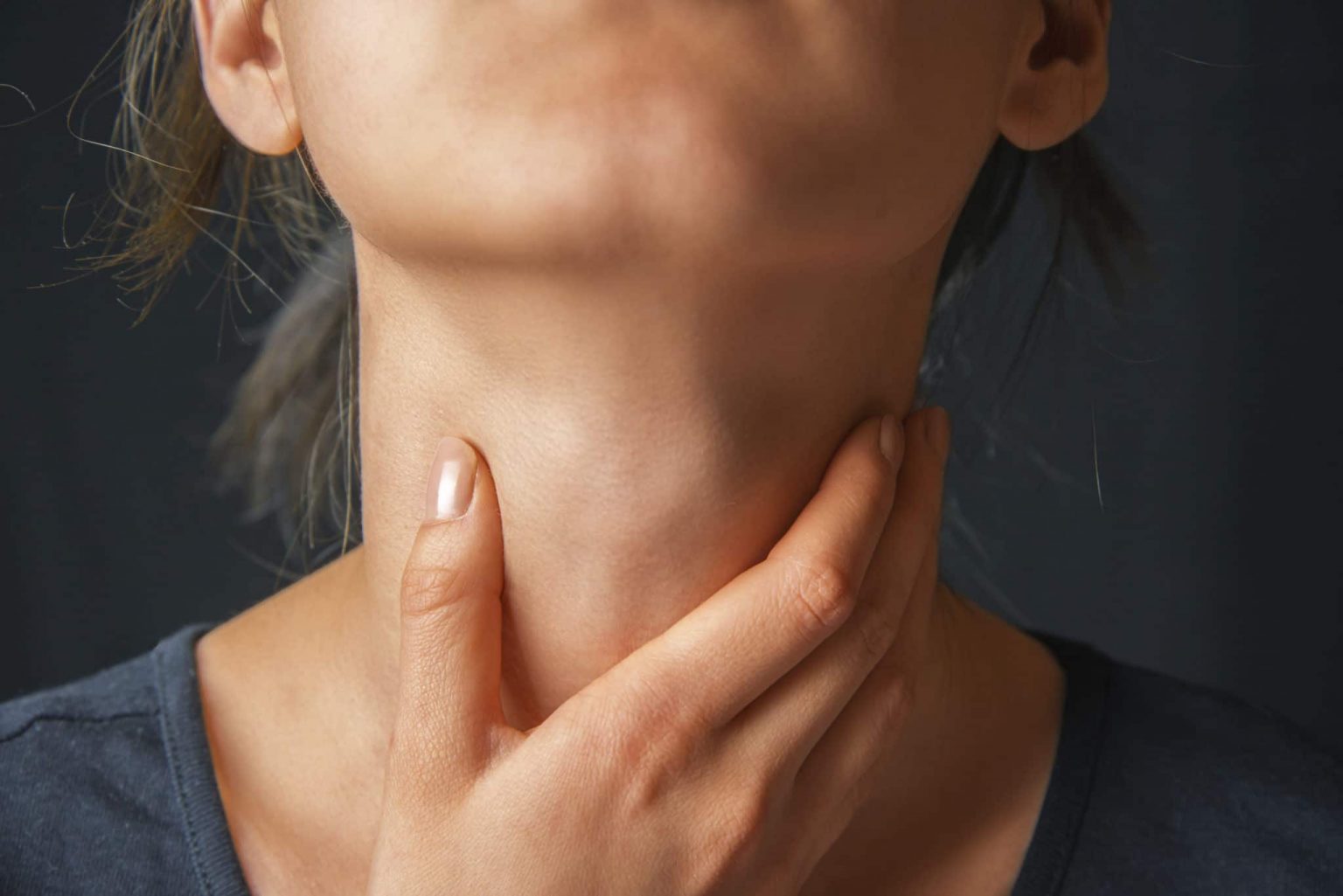 Swallowing-Disorders-exam Woman with hand on throat assessing her swallowing disorder.