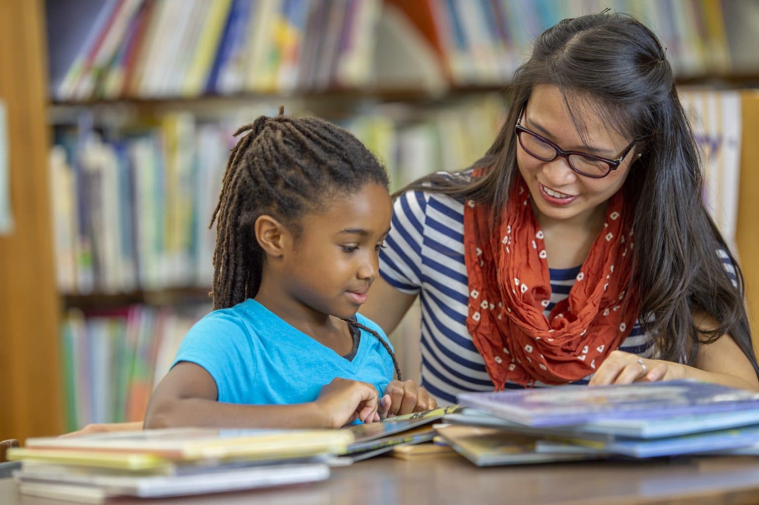 speech language lessons A female teacher is helping a child female student with a speech and language therapy.